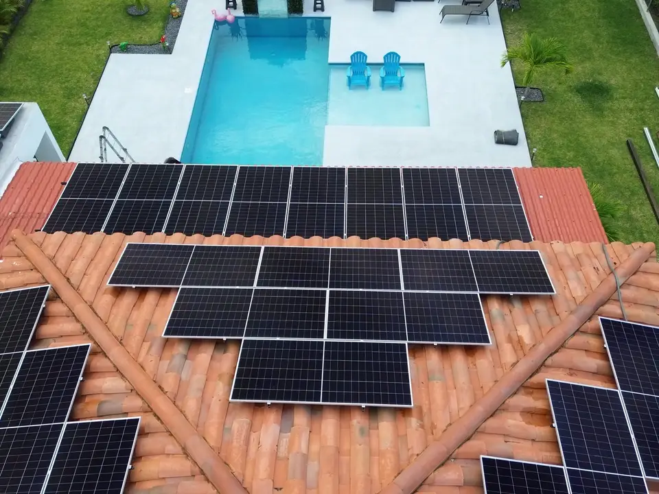 Casa en Panamá con paneles solares sobre techo de teja, vista desde dron